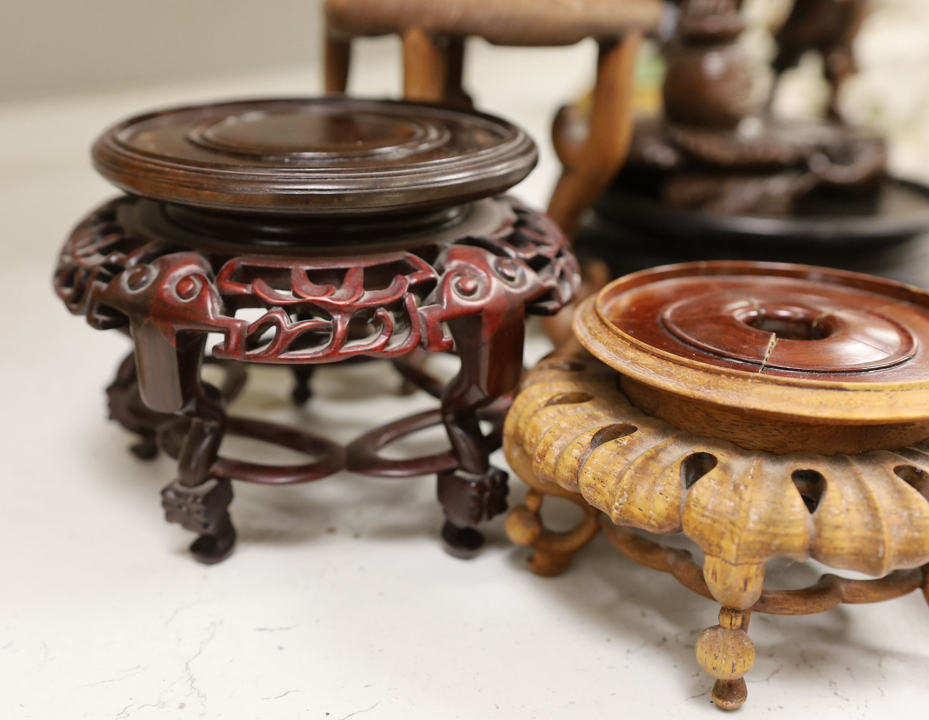 A Chinese hardwood figure of fisherman, 42cm tall including stand, and a quantity of wooden stands